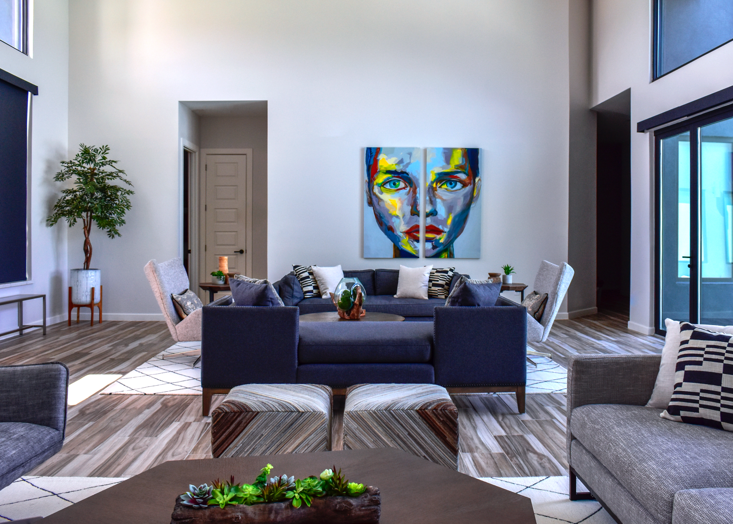 Modern living room designed by Diva by Design featuring a charcoal sofa, abstract artwork, and an open, intentional layout that creates a peaceful atmosphere.