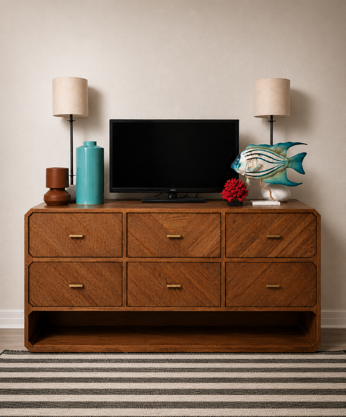 Modern coastal bedroom dresser with a TV, warm wood furniture, turquoise décor accents, contemporary table lamps, and beach-inspired accessories in a stylish condo retreat
