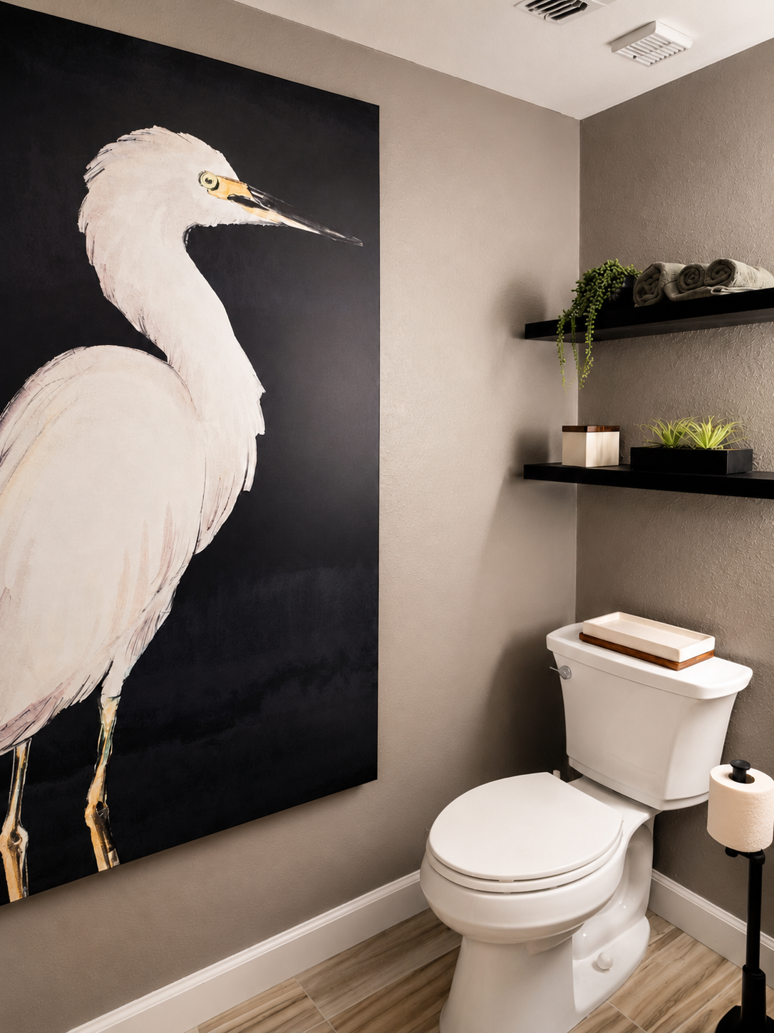 Modern powder room with oversized white heron artwork, floating black shelves, warm gray walls, wood-look tile flooring, and contemporary styling in a luxury coastal condominium