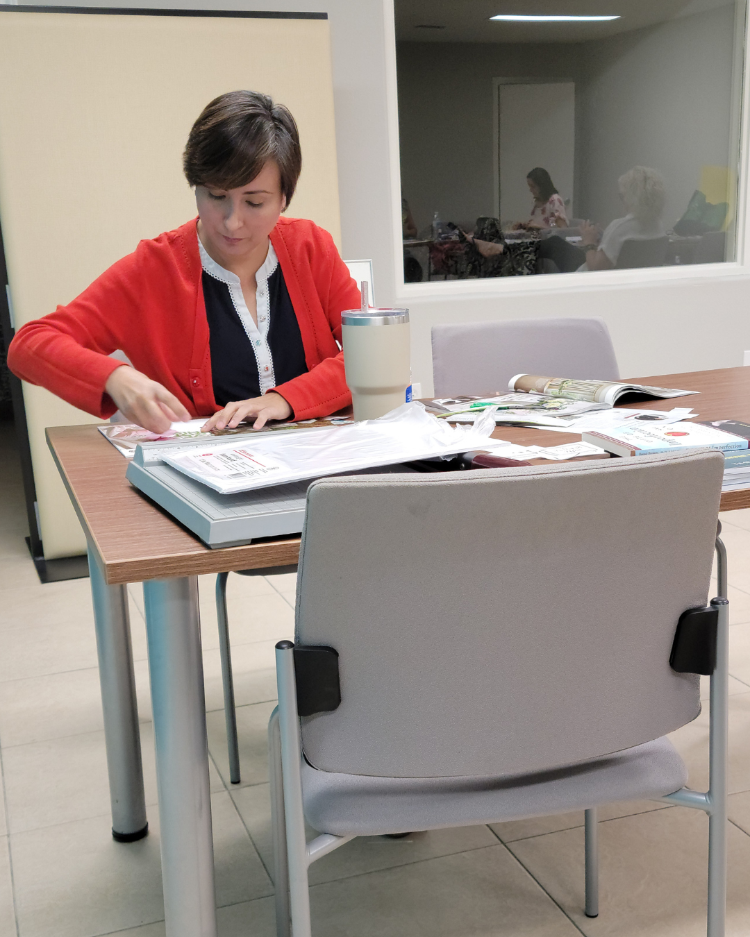 woman sitting at a table making a vision board at a workshop by Diva by Design